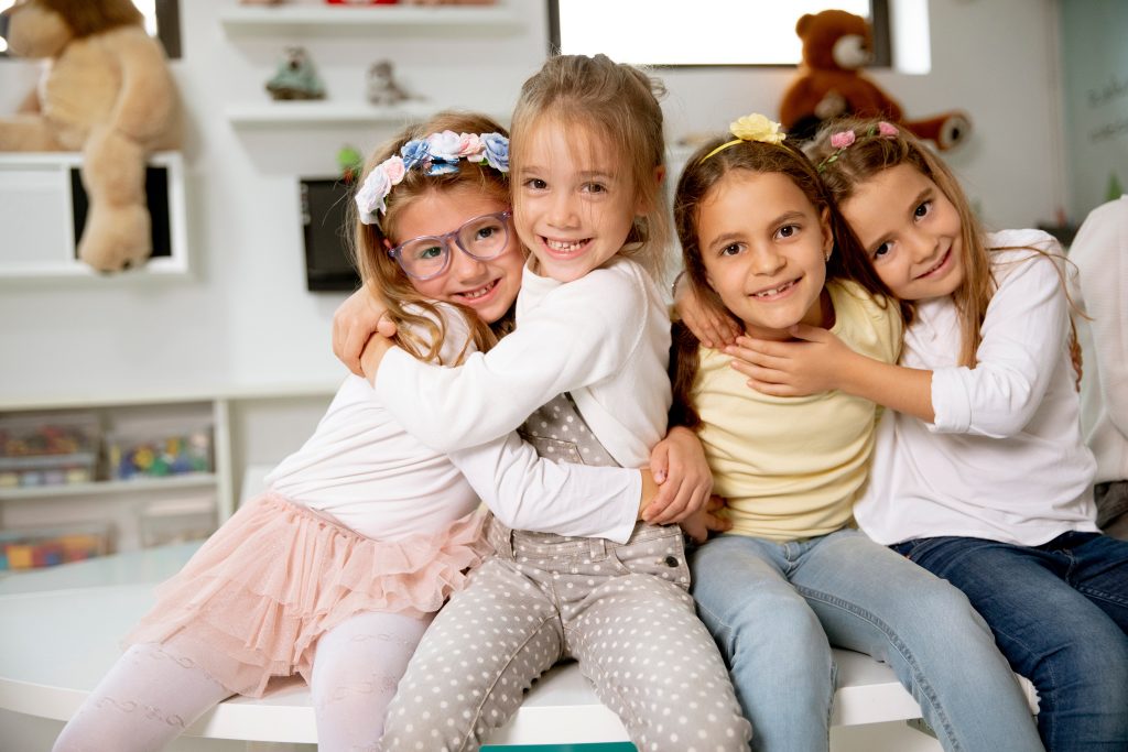 Skupinka kamarátok zo škôlky sedia a zabávajú sa počas Montessori programu v súkromne materskej škole Heuréka Zvolen