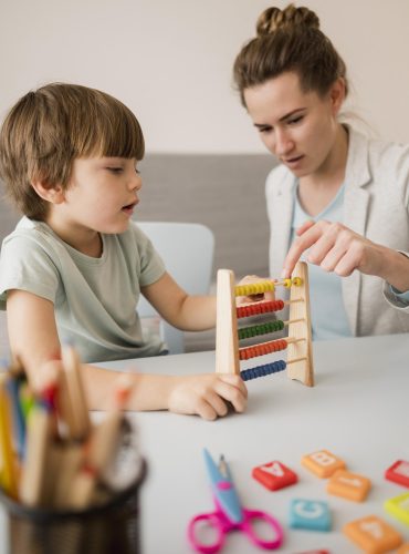 Montessori vo Zvolene - bočný pohľad doučovateľ učí dieťa ako používať počítadlo